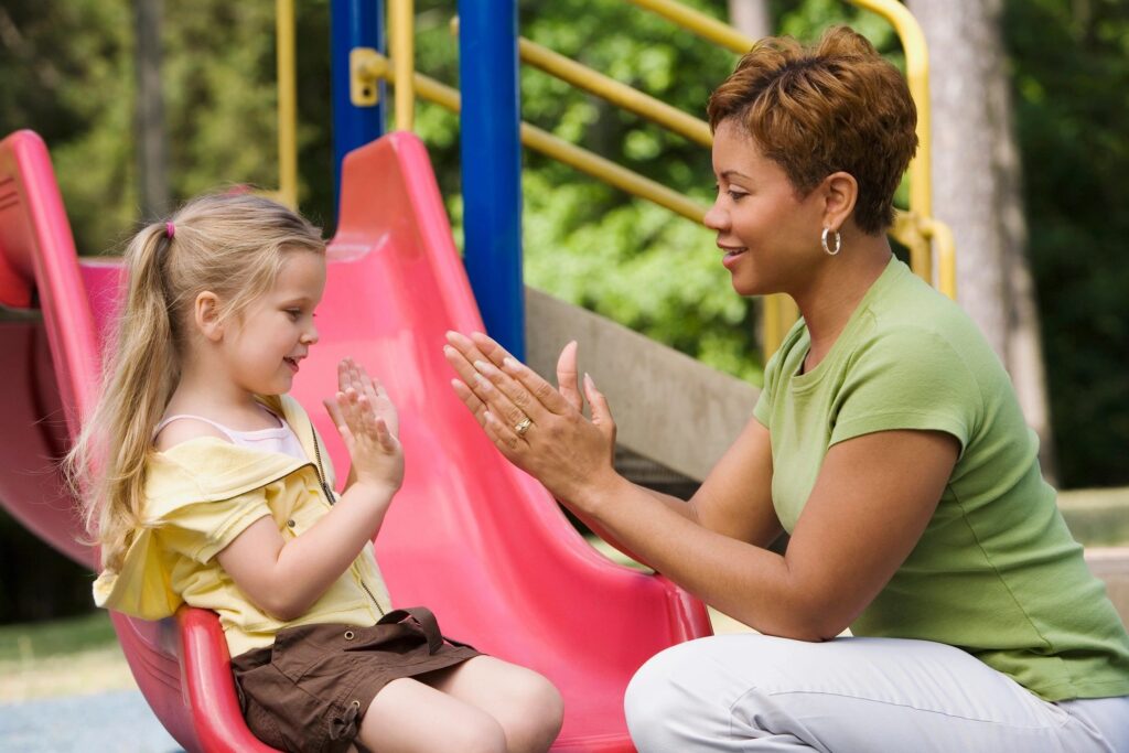 Woman and child playing patty cake