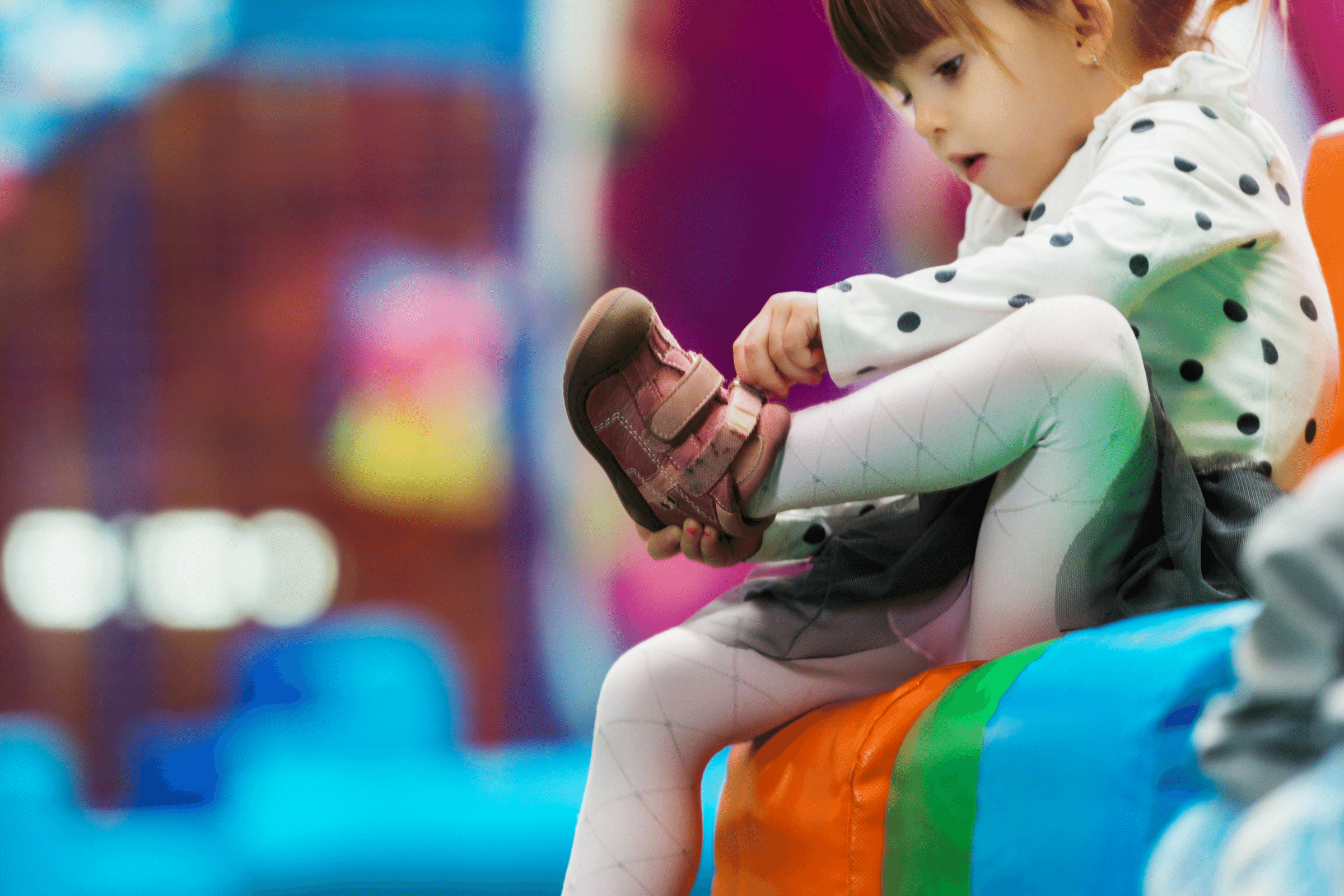 Young girl putting on shoes