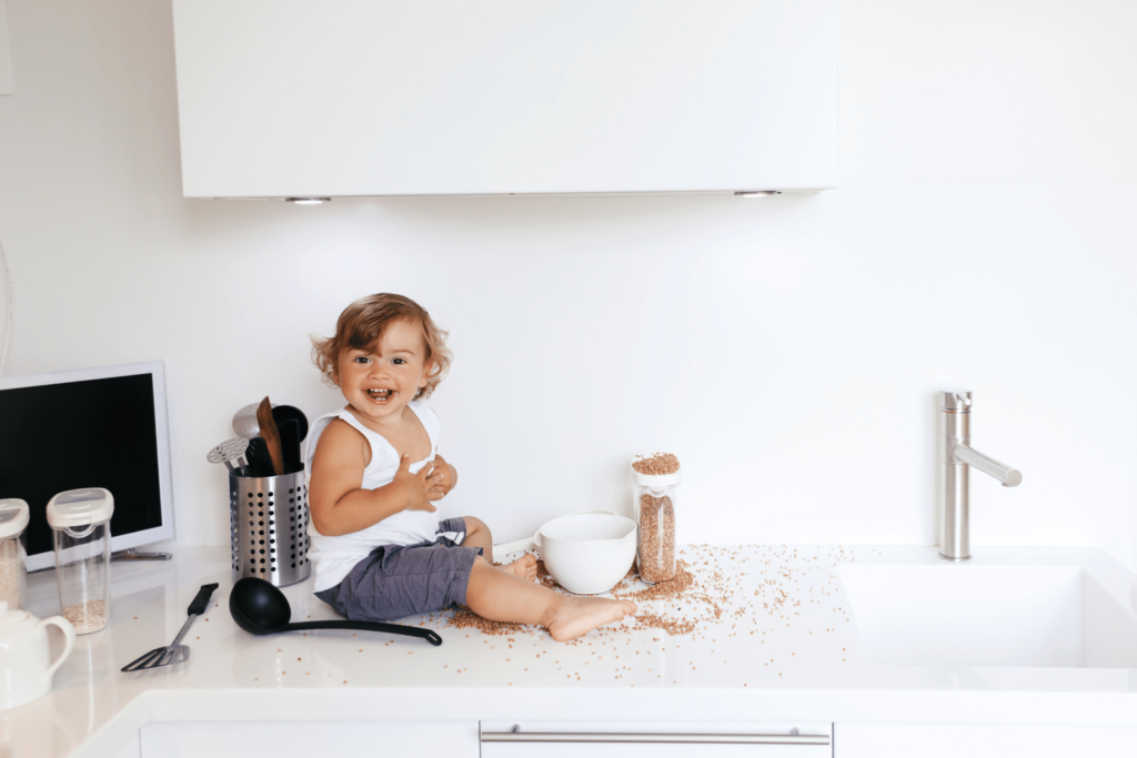 Child making mess with cereal on counter