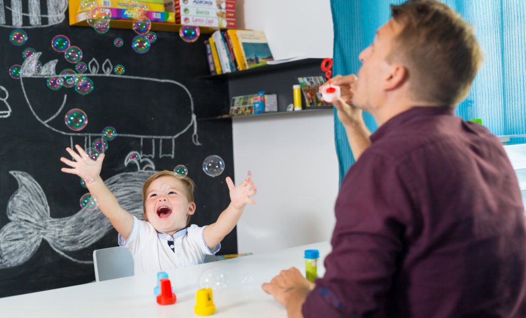 Man blowing bubbles for child