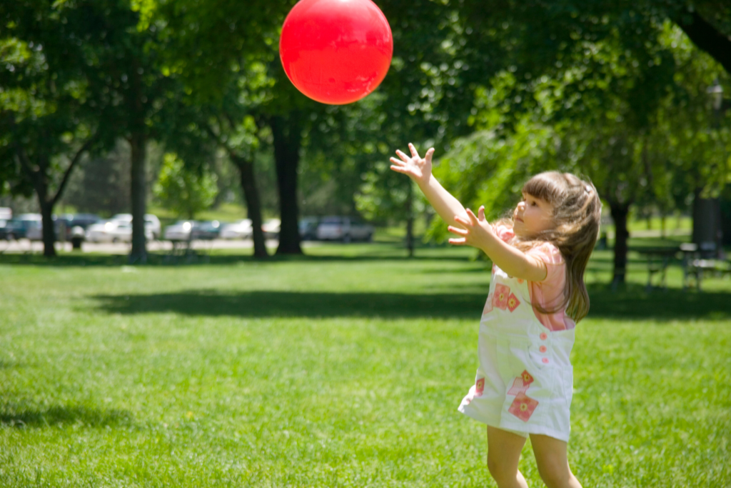 girl catching ball outside