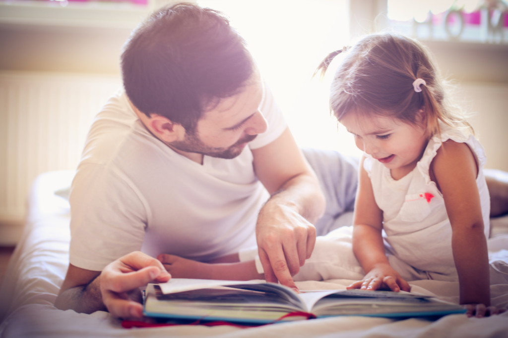 dad reading to toddler daughter