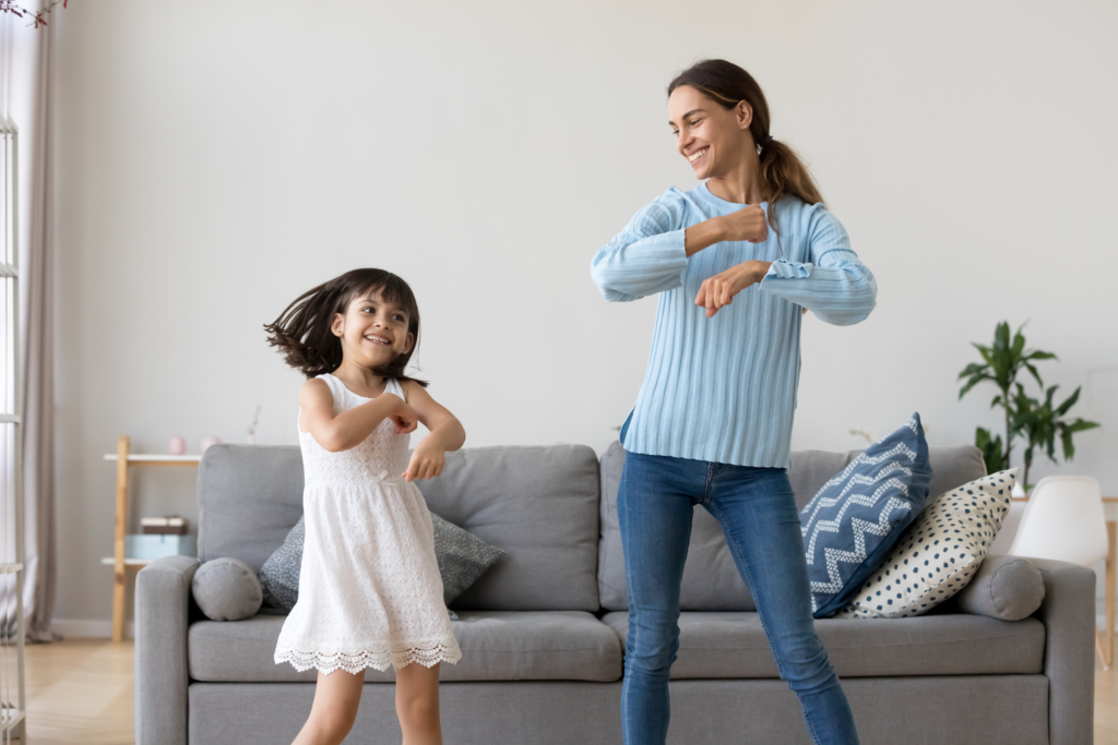 woman and young girl dancing in living room